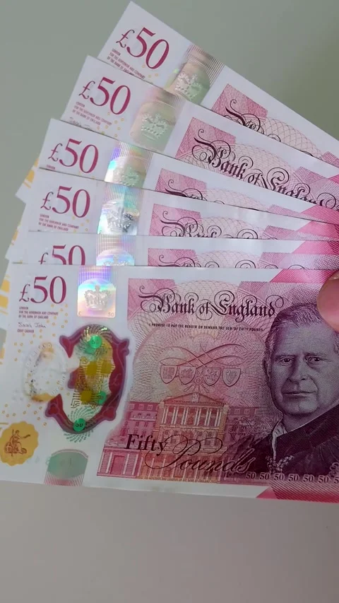 Hand brings six £50 notes totalling £300 into centre frame, slow motion Stock Footage 334238513