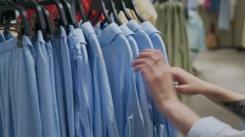 Hand Browsing Blue Pants and Shirt on Hanger Stockbeeldmateriaal 311879698