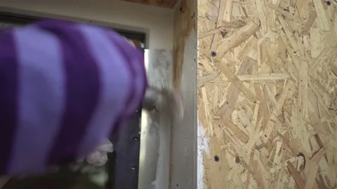 Hand with brush carefully paints slopes of windows of his own wooden house Stock Footage 238699448