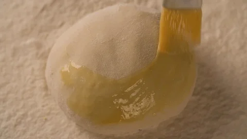 Hand with a brush lubricates dough pie cake with melange top view Stock Footage 102620010