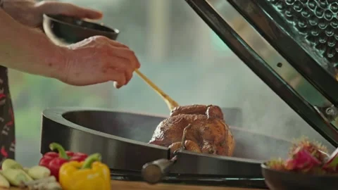 Hand brushing roasted whole chicken on a the grill bbq barbeque kamado camado Stock Footage 292808751
