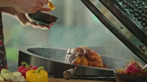 Hand brushing roasted whole chicken on a the grill bbq barbeque kamado camado Stock Footage 292808800