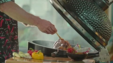 Hand brushing roasted whole chicken on a the grill bbq barbeque kamado camado Stock Footage 292808846