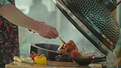 Hand brushing roasted whole chicken on a the grill bbq barbeque kamado camado Stock Footage 292808864