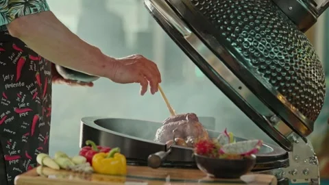 Hand brushing roasted whole chicken on a the grill bbq barbeque kamado camado Stock Footage 292809639