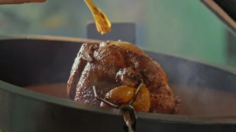 Hand brushing roasted whole chicken on a the grill bbq barbeque kamado camado Stock Footage 292810756