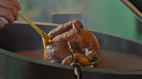 Hand brushing roasted whole chicken on a the grill bbq barbeque kamado camado Stock Footage 292810946