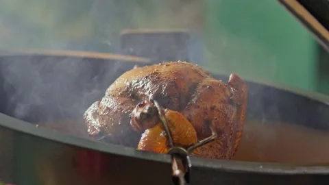 Hand brushing roasted whole chicken on a the grill bbq barbeque kamado camado Stock Footage 292811088