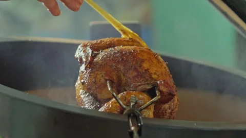 Hand brushing roasted whole chicken on a the grill bbq barbeque kamado camado Stock Footage 292811508