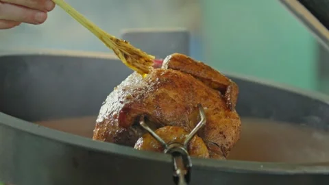 Hand brushing roasted whole chicken on a the grill bbq barbeque kamado camado Video stock 292811730