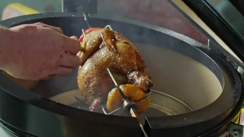 Hand brushing roasted whole chicken on a the grill bbq barbeque kamado camado Video stock 292812724