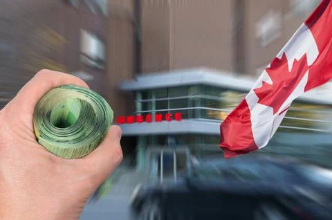 Hand with bunch of bank notes in front of Canadian hospital emergency entranc Stock Photos