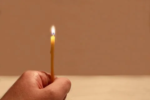 Hand with a burning candle Stock Photos