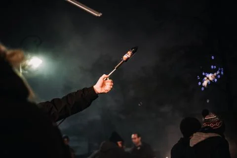 Hand with burning firecracker rocket , rather dangerous Foto stock