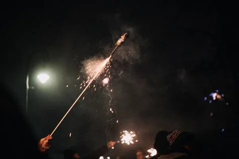 Hand with burning firecracker rocket , rather dangerous Foto stock