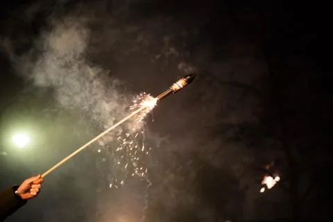 Hand with burning firecracker rocket , rather dangerous Stock Photos