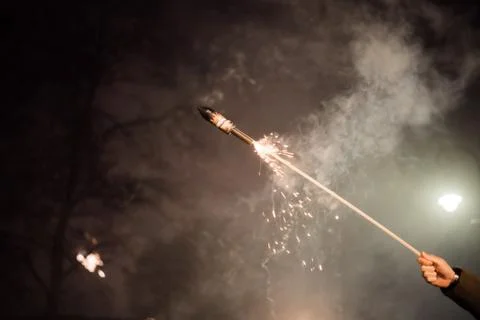 Hand with burning firecracker rocket , rather dangerous Foto stock