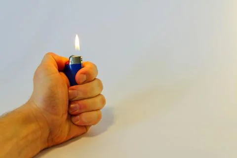 Hand burning a lighter on white background Stock Photos