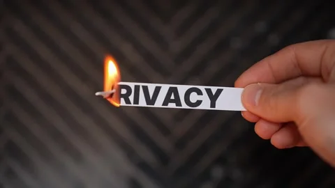 Hand burns a paper label reading “PRIVACY,” symbolizing privacy restored—data Stock Footage 331835246