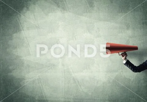 Hand of businesswoman holding red paper trumpet against concrete background Stock Photos