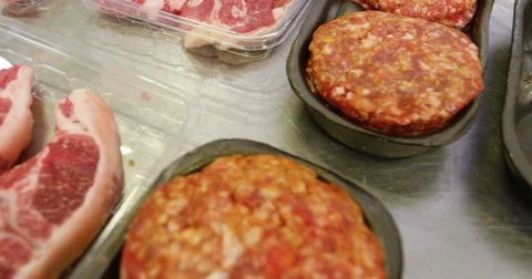 Hand of butcher packing baked meat in container Stock Footage
