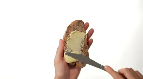 Hand Buttering a Slice of Bread on white background Video stock 27121222