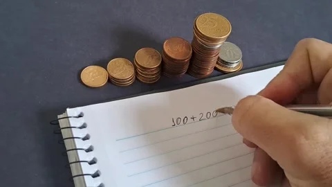 Hand calculating financial growth with stacks of coins 스톡 동영상 345448489