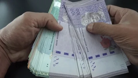 Hand is calculating Ringgit Malaysia banknotes on various values. Stock Footage 95770163