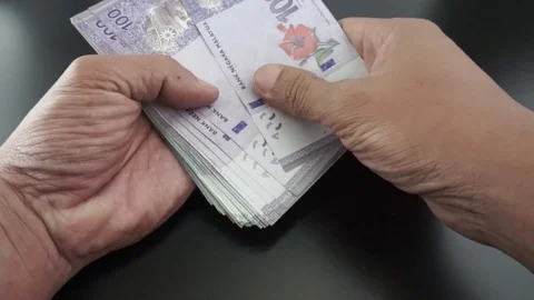 Hand is calculating Ringgit Malaysia banknotes on various values. Stock Footage 95770544