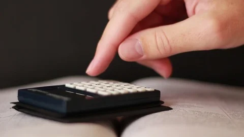 Hand with calculator on book Stock Footage 75628935