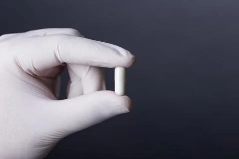 Hand with capsule Stock Photos