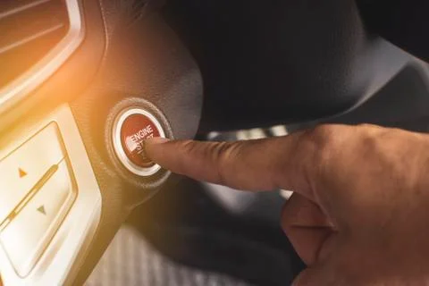 Hand of car driver press to the engine start/stop button for engine ignition  Stock Photos