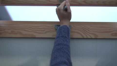 Hand Carefully Adjusting a Window Covering with a Marker for Precision and Style Stock Footage 318543394