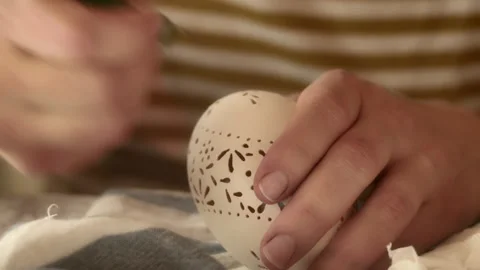 Hand carefully decorates ornate pattern on Easter madeira egg, close-up Stock Footage 152653883