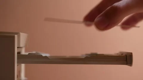 A hand carefully inserting a CD or DVD from a computer's optical disc drive tray Stock Footage 304897998