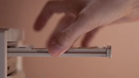 A hand carefully inserting a CD or DVD from a computer's optical disc drive tray Stock Footage 305058928