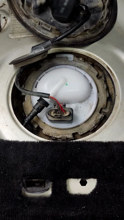 A hand carefully pulls a fuel pump module from car Stock Footage 335834235