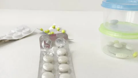 Hand carefully removing pills from silver blister packs and organizing them.. Vídeos de archivo 335141541