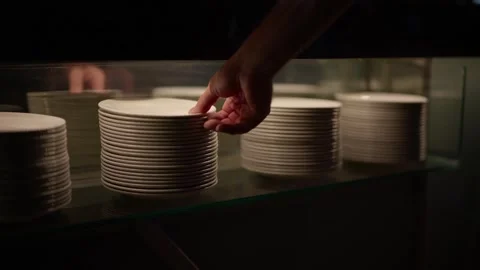 A hand carefully selecting a clean white ceramic plate Stock Footage 346298907