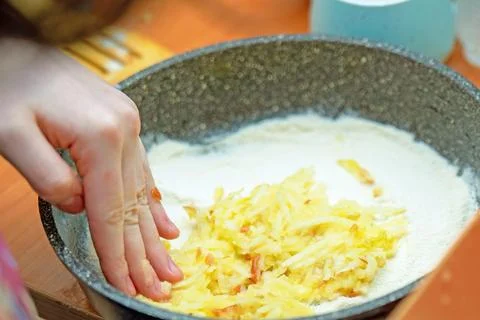 Hand carefully spreads a layer of mashed apples into a pie dish, preparing fo Stock Photos