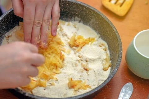 Hand carefully spreads a layer of mashed apples into a pie dish, preparing .. Stock Photos