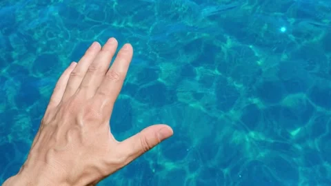 Hand caressing transparent turquoise water surface Stock Footage 306596474