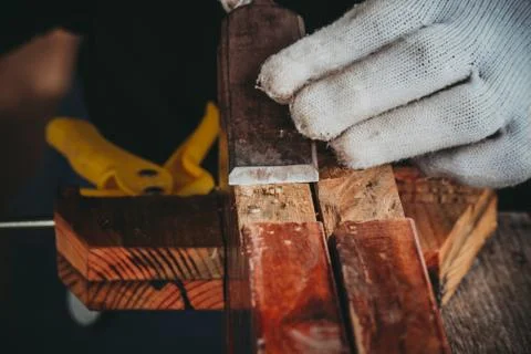 The hand of the carpenter taking the chisel to sharpen the wood plank Stock Photos