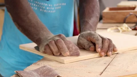 Hand of a carpenter using sandpaper to smoothen surface of a wood. Stock Footage 223791526