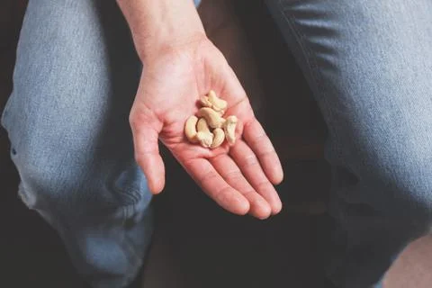 Hand with cashew nuts Photos