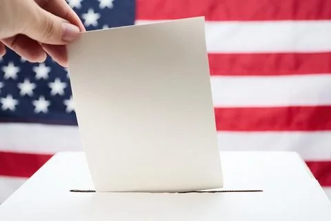 Hand casting vote into ballot box against usa flag Stock Photos