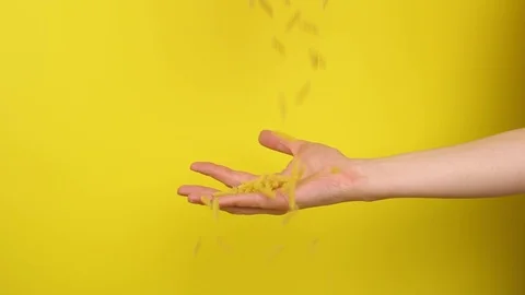 Hand catches pasta on a yellow background Stock Footage 124321136