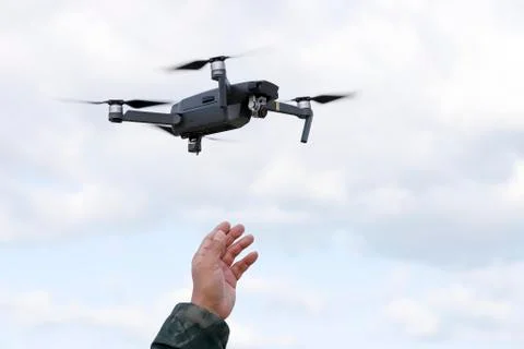 Hand catching drone in sky background Foto stock