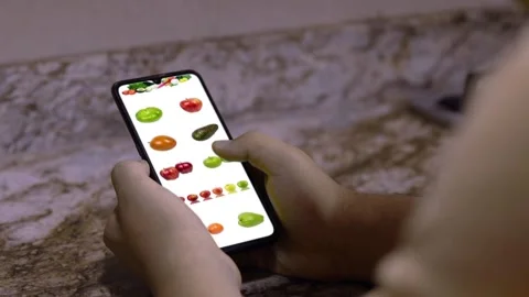 Hand with cell looking for vegetables on screen 02 Stock Footage 136064954