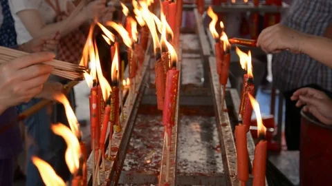 Hand cense joss stick to at an incense burne and burning candle Stock Footage 83791774